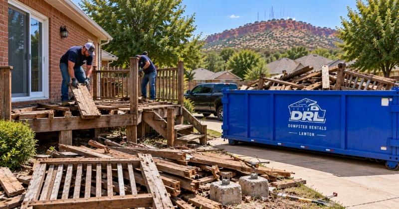 Deck removal debris including wood decking, joists, railings, stairs, and concrete footings being cleared into a dumpster in Lawton, Oklahoma