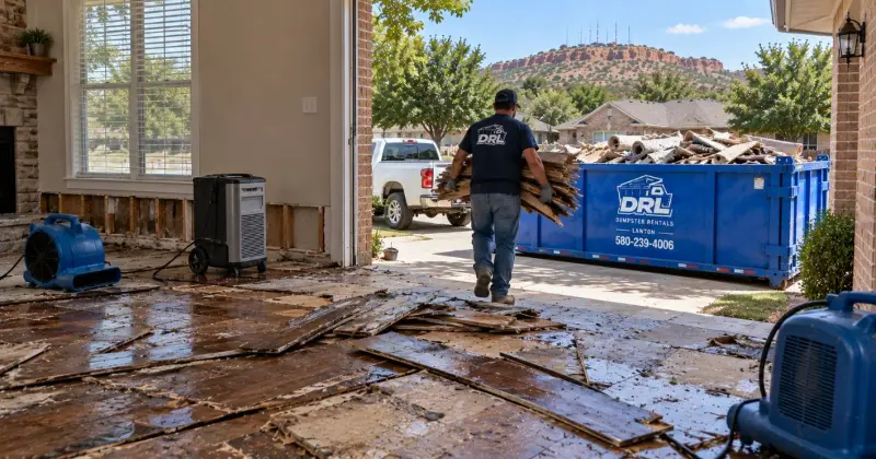 Water-damaged flooring being removed from a home and loaded into a dumpster during cleanup in Lawton, Oklahoma