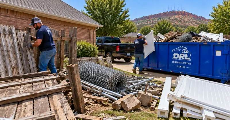 Wood, chain link, and vinyl fence materials being removed and loaded into a roll-off dumpster in Lawton, Oklahoma